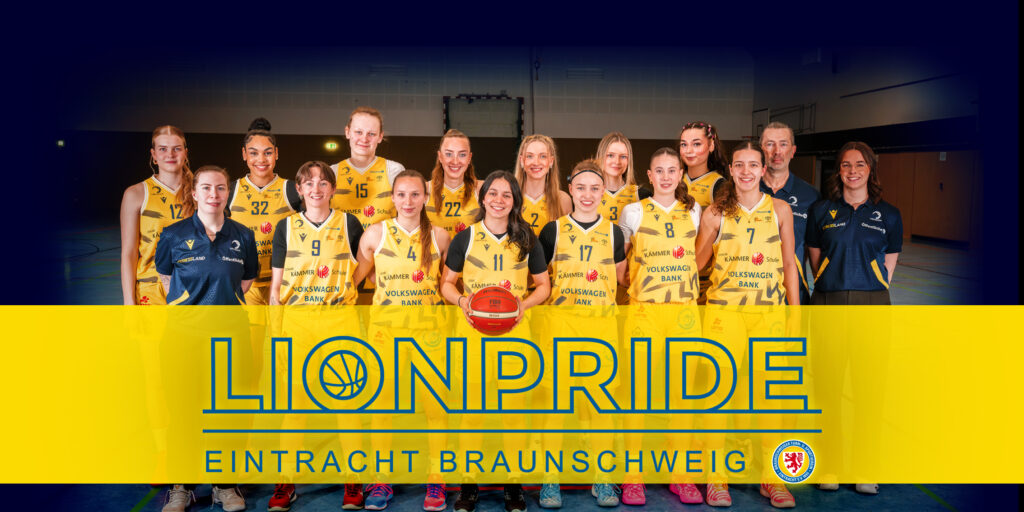 Frauen Basketballmannschaft in gelben Trikots lächelt gemeinsam in einer Sporthalle