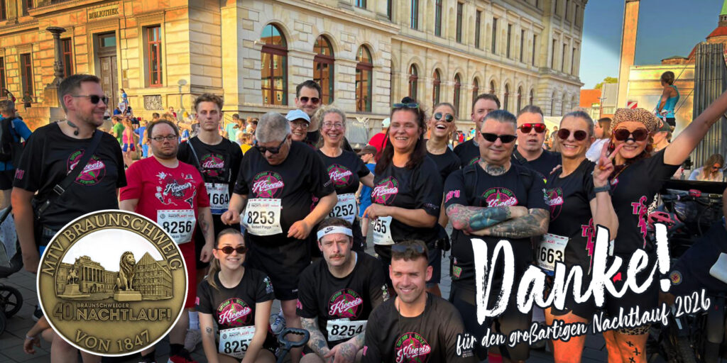 Laufgruppe mit lächelnden Personen in Schwarz Rosa vor Altstadtgebäude und Danke Schriftzug