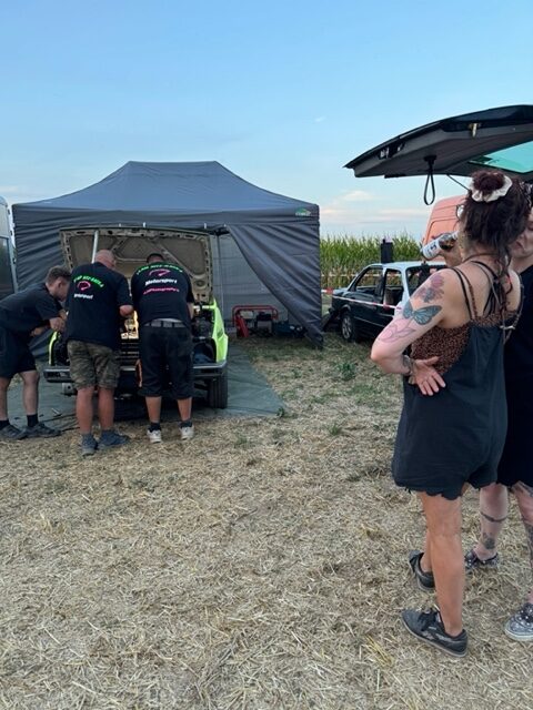 Menschen an einem Zelt auf einem Feld bei einer Motorsportveranstaltung