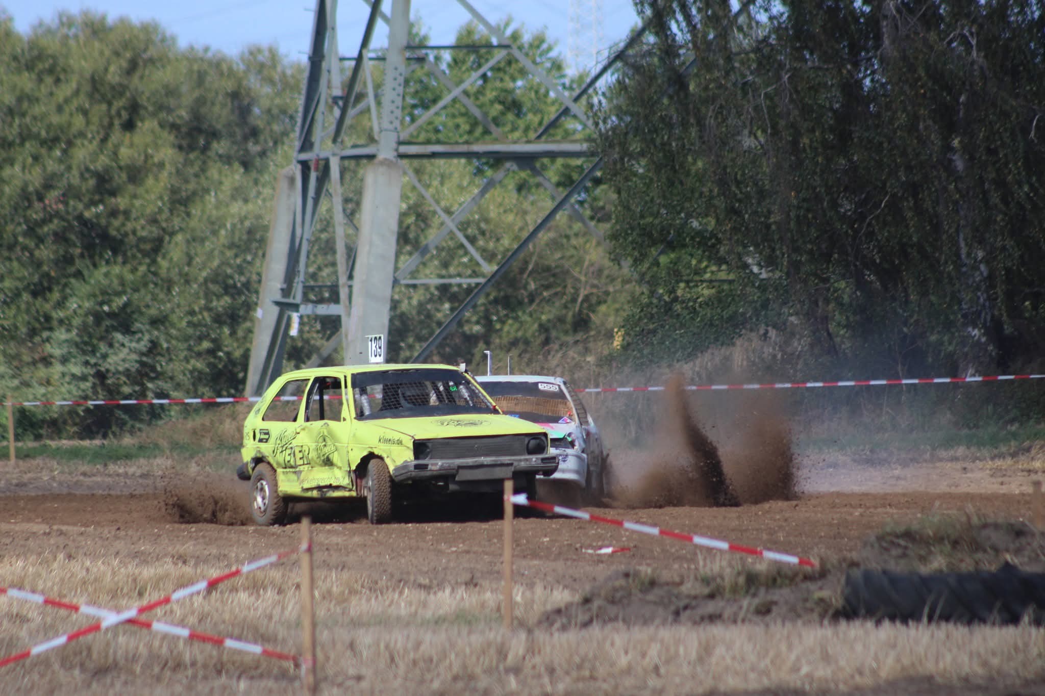 Zwei Autos beim Stockcarrennen auf einer staubigen Strecke im Feld