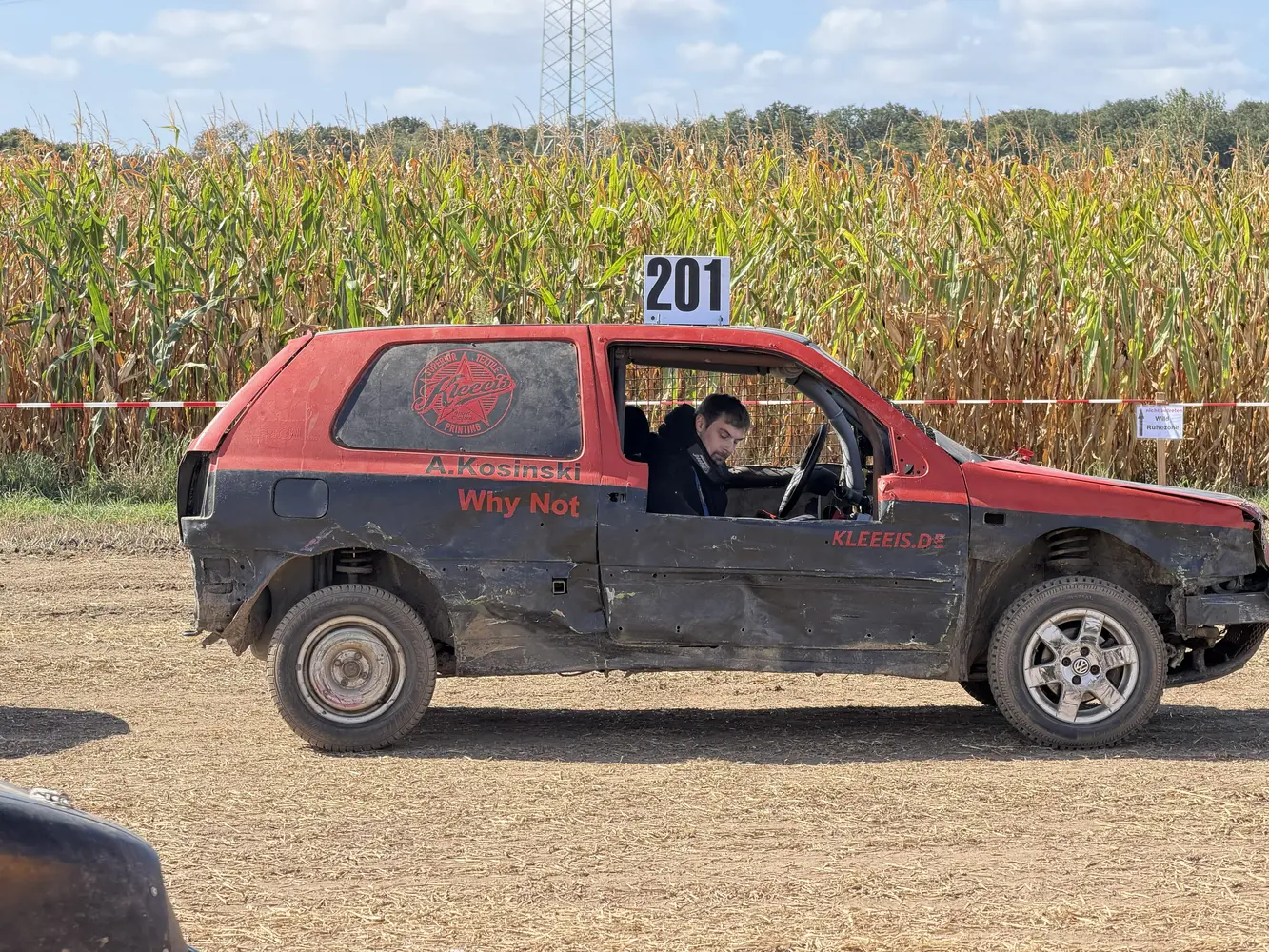 Ein Mann mit Bart sitzt konzentriert im roten Stockcar mit Nummer 201